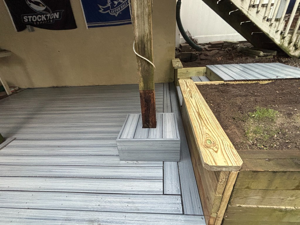 Grey composite deck with picture-frame trim and wood planter