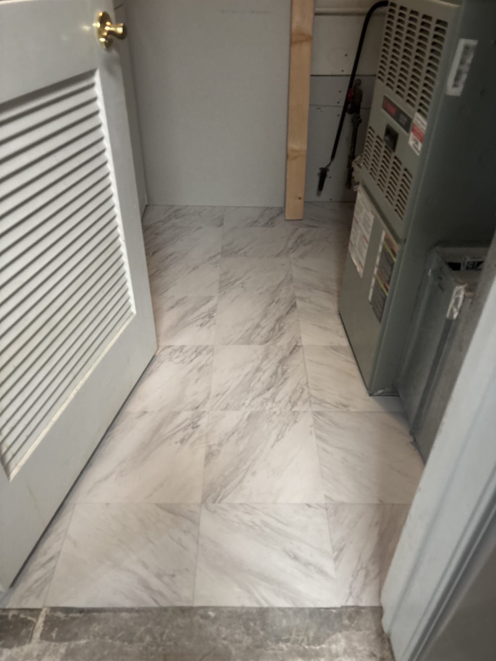 Utility room marble floor tile beside a furnace