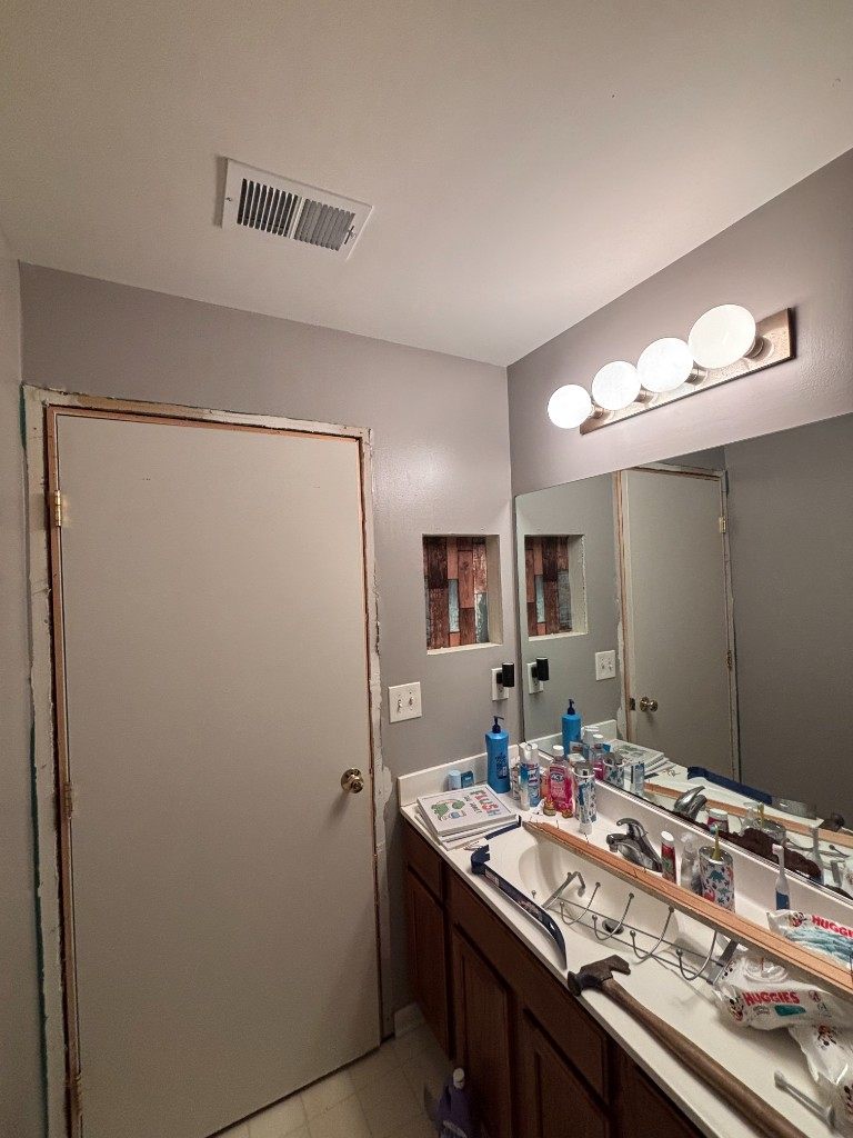 Bathroom renovation in progress, vanity with tools and wood-lined wall niche