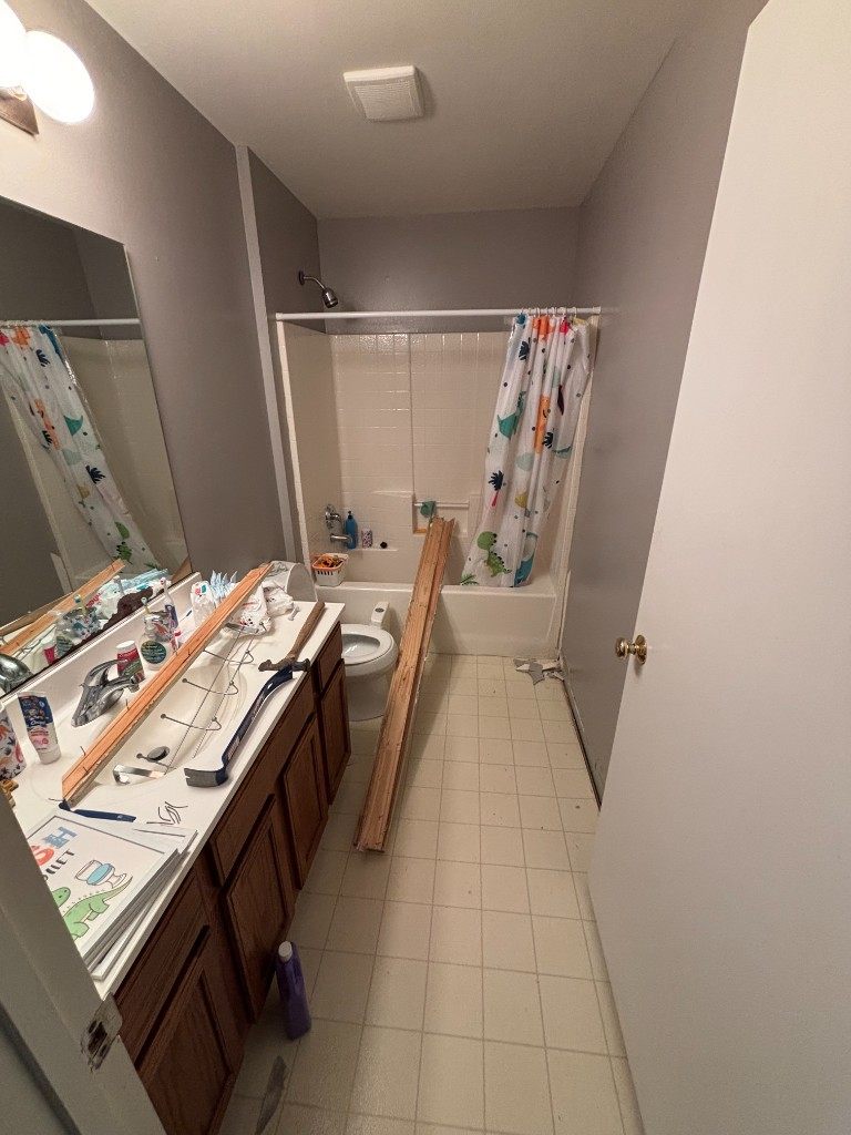 Bathroom during demolition, trim and tools at the vanity