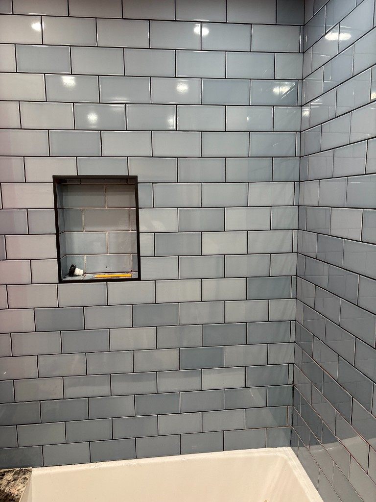 Blue subway tile tub surround with recessed niche