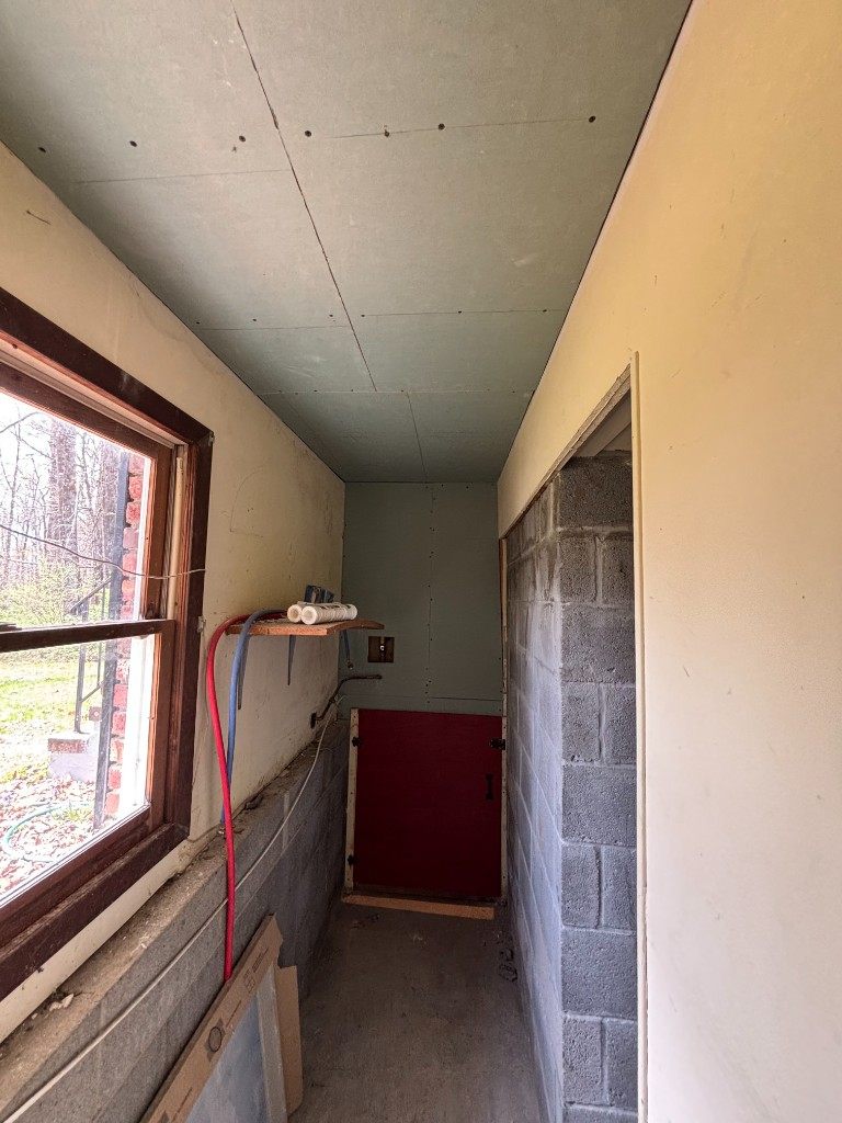 Utility hallway greenboard, window, and PEX piping