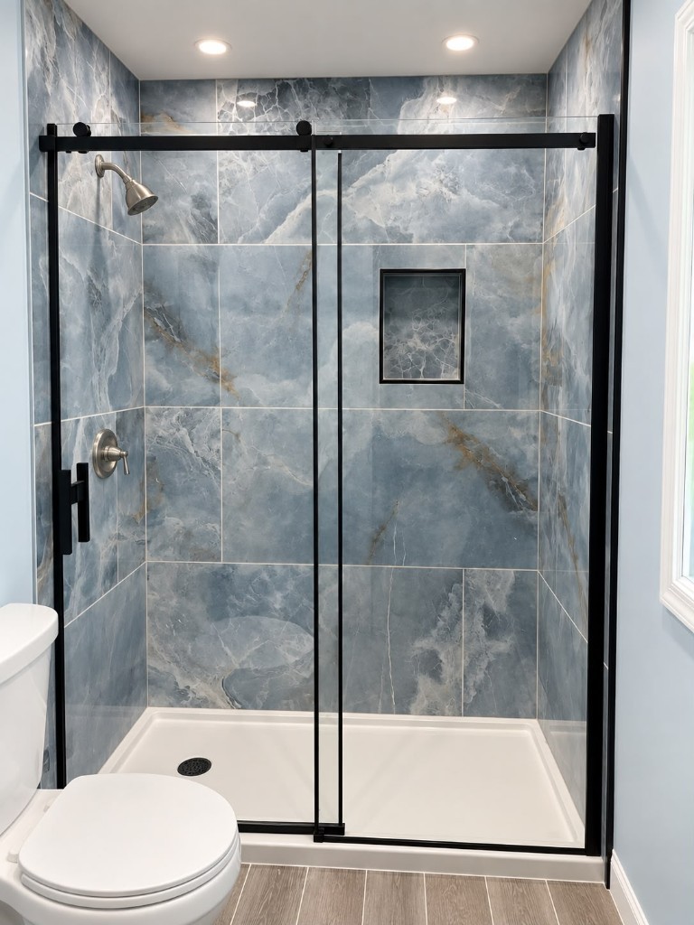 Finished walk-in shower with marble-look tile and black glass door