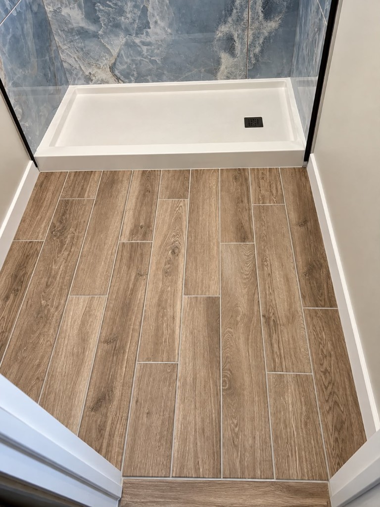 Wood-look plank floor tile at a shower pan